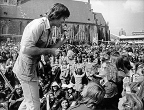 American singer, actor and director dean reed performing on an open air stage at berlin's neptune fountain during 10th free german youth parliament / festival of youth, east berlin, gdr, june 5, 1976.