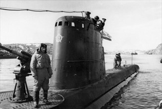 Northern fleet, hero of the soviet union, commander i, fisanovich stands by the gun watching 'baby' being moored.