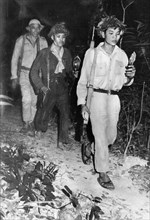 South vietnamese communist guerrillas on the ho chi minh trail at night, vietnam war, 1964, guerrillas carrying tiny lamps made from perfume bottles.