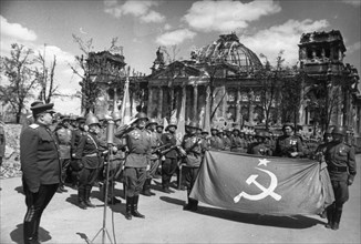 Red army victory ceremony in front of ruined reichstag (chancery) building, berlin, germany, may 1945.