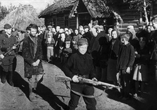World war 2, a russian traitor being marched from the open air courtroom where he had been judged by the villagers, the procession is being led by a 13 year old guard, a full-fledged partisan scout, f...
