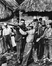 Fidel castro giving rifle instruction to new recruits to his revolutionary army in sierra maestra, a guerrilla base in cuba, late 1950s.
