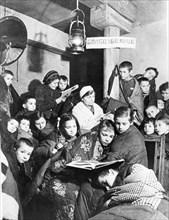 world war ll: leningrad during the blockade, during an air raid alert children take cover in the nearest bomb shelter.