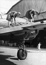 Two women working on the metal covering of a wing of a soviet military plane during world war 2, september 1944.