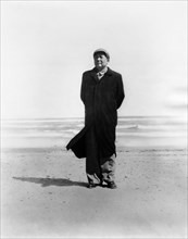 Mao zedong, chairman of the central committee of the communist party of china, standing on a beach by the ocean.