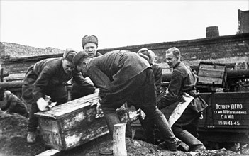 Men loading dismantled factory machinery onto railroad cars for evacuation to the urals, 1941.