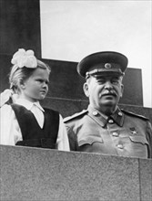 Joseph stalin at a may day celebration with first grade student vera kondakova, may 1, 1952, she stepped out of a column of pioneers and presented the premier with a bouquet of flowers.
