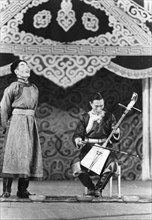 Mongolian folk singer dolgor zhab sings traditional song 'dumun', muru dorzhi accompanies him on horse head fiddle, moscow, ussr, september 1947.