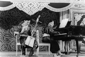 Mongolian musician dzhamyan performs a piece by schumann on a two stringed folk instrument called a marinkura (horse head fiddle), moscow, ussr, september 1947.