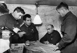 Lt, general vasili chuikov (2nd from left) giving an assignment to the commander of the 13th guards rifle division, major general alexander rodimtsev (far right), in the command post bunker of the 62n...