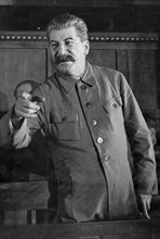 Joseph stalin giving a speach at a session of the commission for studying the project of the model constitution of agricultural artels during the second all-union congress of collective farm shock-wor...