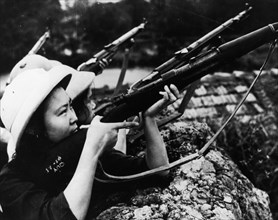 Woman fighters of the self-defense detachment of the march 8 textile mills of hanoi ready to repulse an american air attack, north vietnam, april 1965.