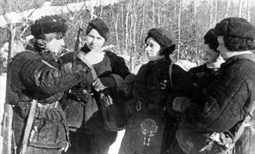 T, shebayeva (l), a guerrilla of the serpukhov district, moscow region, after returning from an assignment, describes to other girls her experiences during world war ll.
