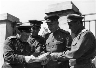 Marshal timoshenko, representative of the headquarters of the supreme command of the red army (second from right), explaining a new combat assignment to colonel-general kravchenko (right) for his tank...