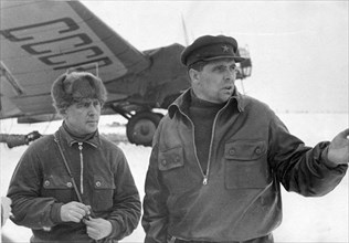 Hero of the soviet union m,v, vodopyanov, commander of the flagship plane ussr n-170, and chief navigator of the expedition maj, i,t, spirin, at the airdrome in kholmogory on the way to rudolf island,...