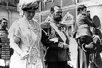 The royal couple of russia, tsar nicholas ll and tsarina alexandra fyodorovna, walking from the assumption cathedral to the nikolayevsky palace, may 25, 1913, the boy is their son, prince alexei.