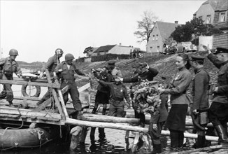 Soviet red army troops meeting the troops of the 1st american army as they cross the elba river near torgau, germany on april 25, 1945.