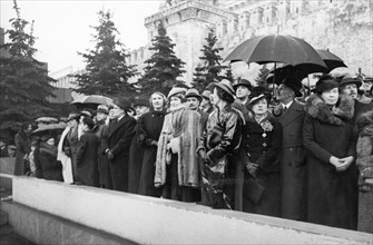 Members of the diplomatic corps with friends and family in red square, watching a demonstration, mrs, joseph davies, wife of the american ambassador to the ussr, is in the center (w/ light hat & cape)...