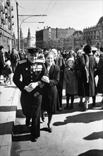 A red army soldier and his girlfriend on gorky street after the victory day celebrations in red square on may 9, 1945, the towers of the moscow kremlin can be seen in the background.