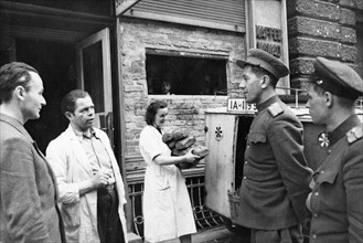 Distribution of bread to the population of berlin, the soviet military commandant of the mitte district talking to the owner of a bakery on strausenstrasse in berlin, 1945 or 1946.