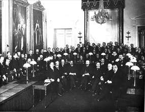 Petrograd, russsia 1917: first members of the provisional government in the state council chamber, alexander kerensky standing second from right (of faces not in shadow) .