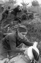 World war 2, 18 year old militsa belobaba, a stretcher-bearer of a yugoslavian partisan detachment, bandaging a wounded man.
