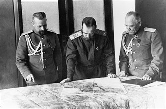 The first world war, supreme commander-in-chief tsar nicholas ll with general (infantry) alexeyev, chief of staff, and major-general pustovoitenko, quarter-master of the staff, looking over a map in n...