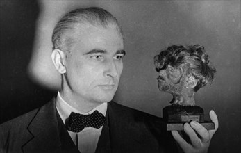 Nuremberg war crimes trial, world war 2, american prosecutor thomas j, dodd holding a shrunken head that decorated the desk of the chief of the buchenwald death camp, head of a male concentration camp...