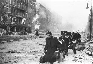 German civilians fleeing berlin under the red army attack, world war 2, city in ruins, 1945.