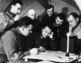 Lieutenant-generat pavel belov (center) going over battle plans at his headquarters, world war ll.