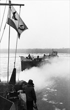 World war 2, soviet armored cutter 'stalinets' of the soviet danube military flotilla towing a captured german barge loaded with supplies on the danube river, february 1945.