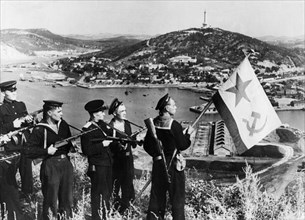 Operation august storm (battle of manchuria), a landing party of sailors of the soviet pacific fleet hoisting a flag over port arthur bay, manchuria, september 1945.