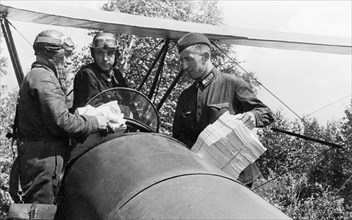 World war 2, propaganda leaflets being loaded onto a polikarpov po-2 (u-2) airplane, the leaflets will be dropped behind enemy lines for the germans to read, july 1942.