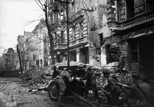 Soviet red army soldiers engaged in street fighting in berlin, germany during world war 2, 1945.