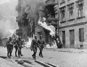 German soldiers walking by fires set in the warsaw ghetto, which was burned to the ground after the uprising, world war ll, poland, 1944.
