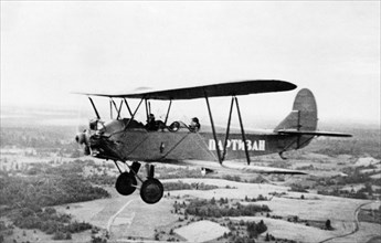 World war 2, a partisan airplane (polikarpov po-2) flying over leningrad territory, the word partisan is written on the side of the plane.