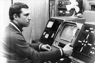 Luna 21 mission, a technician working the controls of the soviet remote-controlled lunar rover, lunokhod 2 at the distant space communications center,  january 1973, (wire photo).