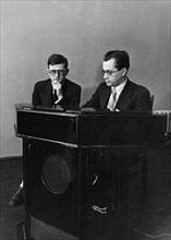 Soviet composer, dmitri shostakovich (left), with a, ivanov, the designer of a new electronic musical instrument called the emiritone, ivanov is demonstrating the new instrument, april 1941.