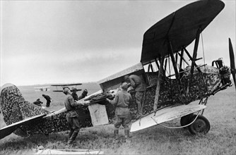 A wounded red army soldier being loaded into a polikarpov po-2 (u-2) plane during world war 2.