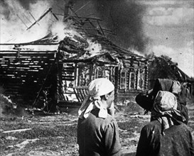 World war 2, soviet women watch as their homes burn with fire set by retreating germans.
