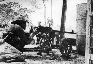 A nlf (national liberation front) fighter firing a machine gun at his post in sguemtri faun, in the village of mi tho, south vietnam, february 1969.