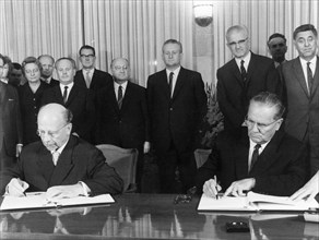 Walter ulbricht of the gdr and josip broz tito, president of the socialist federal republic of yugoslavia and secretary general of the league of communists signing a joint statement on october 1, 1966...