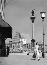 King zygmunt's column in royal castle square in the old town section of warsaw, poland, late 1940s, in the background is st, john's cathedral which is in the process of being rebuilt/renovated.