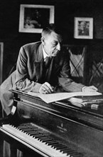 Russian composer, sergei v, rachmaninov, looking over a manuscript at his piano in the late 1920s.