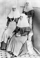 Empress alexandra and her daughters olga and tatiana after finishing the complete nursing course and receiving diplomas from the international red cross, 1914.
