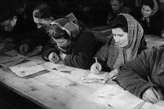 Workers building polish press structure in a classroom for illiterates, up to 50 different courses have been organized in warsaw for illiterates up to 60 years of age, poland, 1949.
