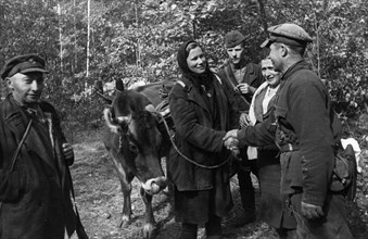 World war 2, collective farmer maria korshun bidding fairwell to fellow partisans as she leaves for her native village, the detachment gave her a cow seized from the germans to replace the one that wa...