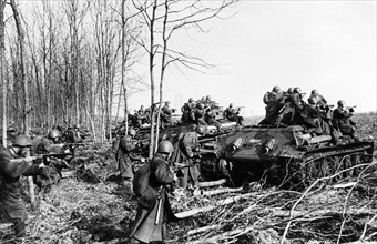 World war 2, red army infantry attacking german positions on the southwestern front, using t-34 (model 41) tanks for cover.