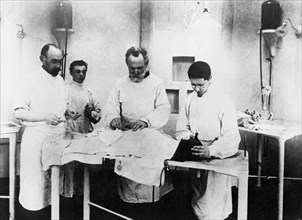 Ivan pavlov (second from right) in his laboratory, operating on one of his dogs.