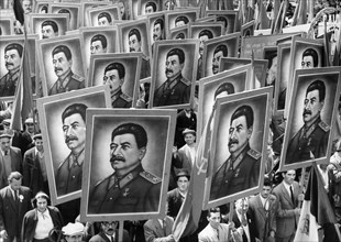 Citizen marchers carrying posters of joseph stalin at a may day parade in bucharest, romania, 1950s.
